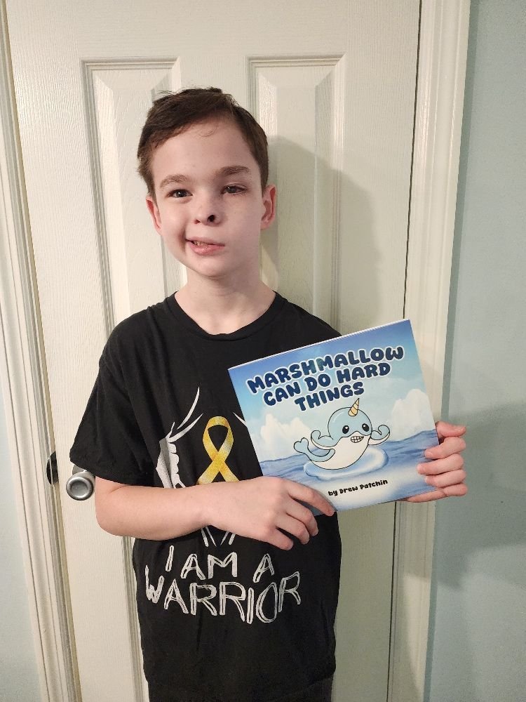 Drew Patchin holding his book, Marshmallow Can Do Hard Things